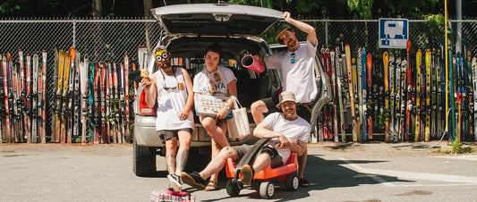 A group of four, sat out the back of a truck